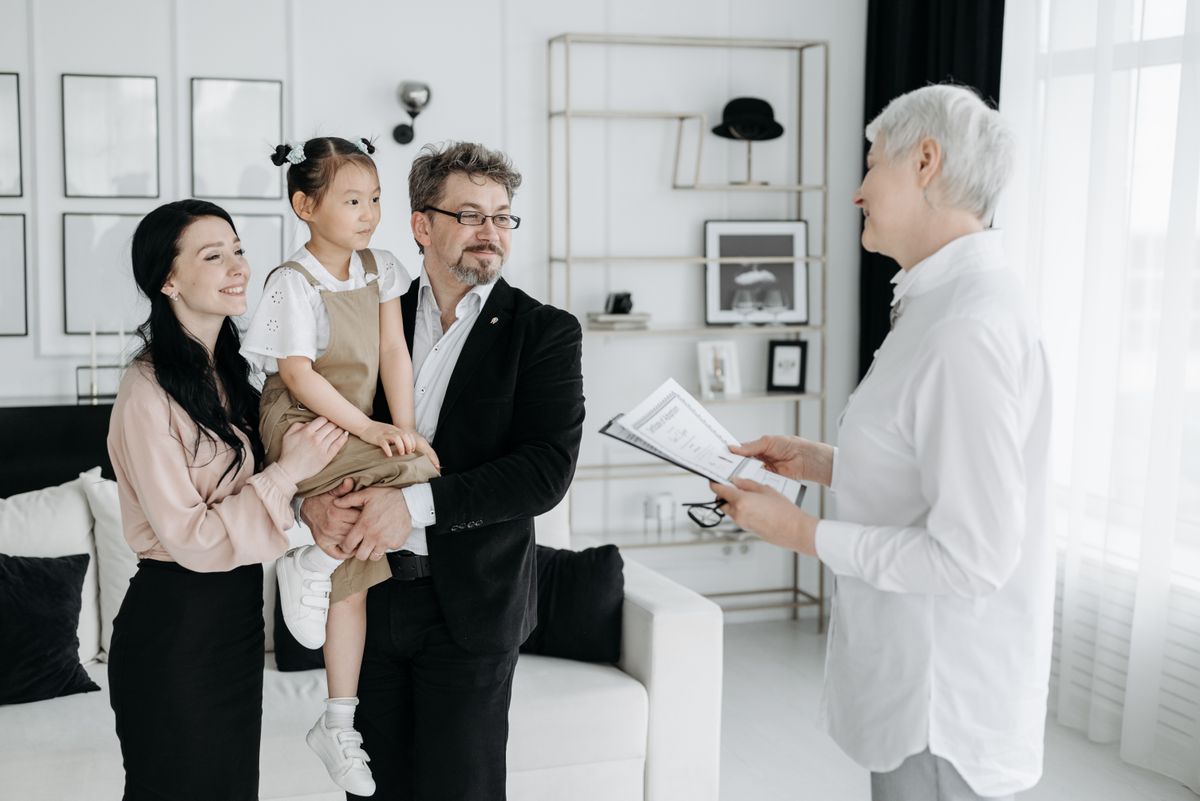 An adoptive family meeting warmly with a social worker indoors