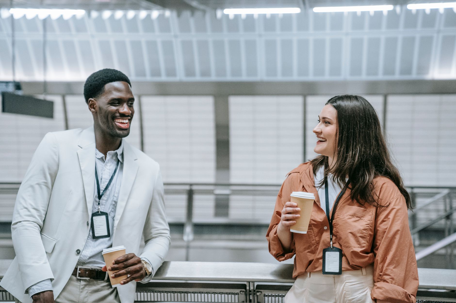 Two people in conversation, one holding an identification card