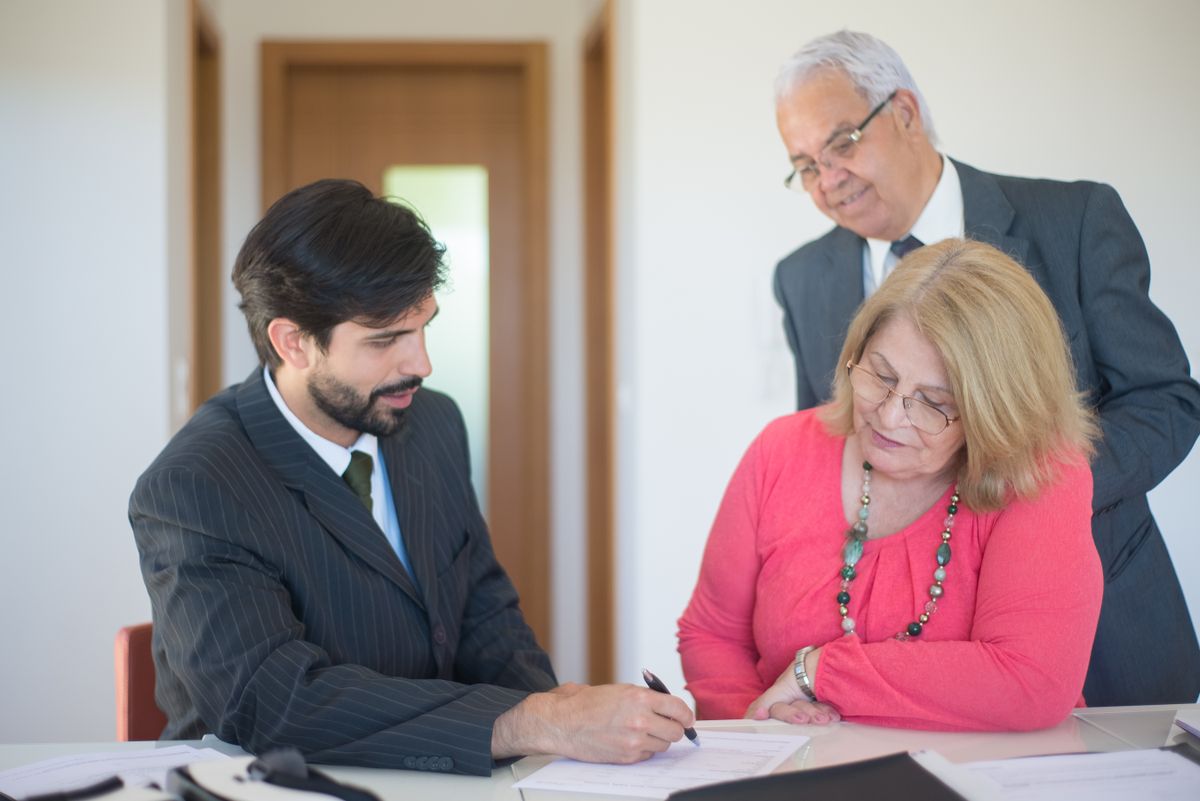 A senior couple reviewing paperwork with an advisor