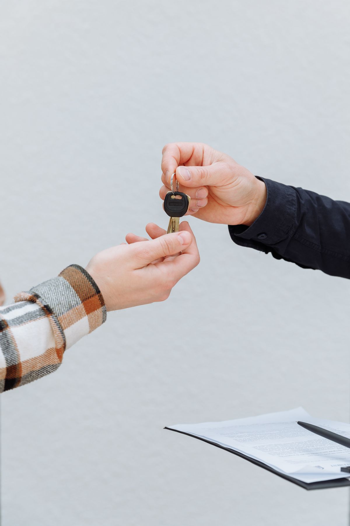 A hand passing over a set of car keys to another person