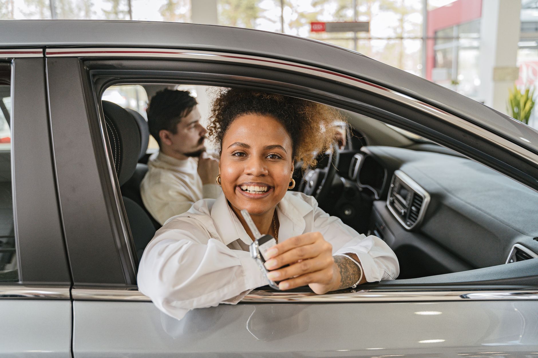 A set of car keys being handed from one person to another