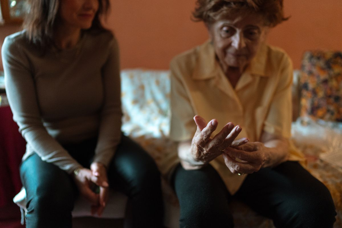An elderly woman and her caregiver sharing a quiet moment at home
