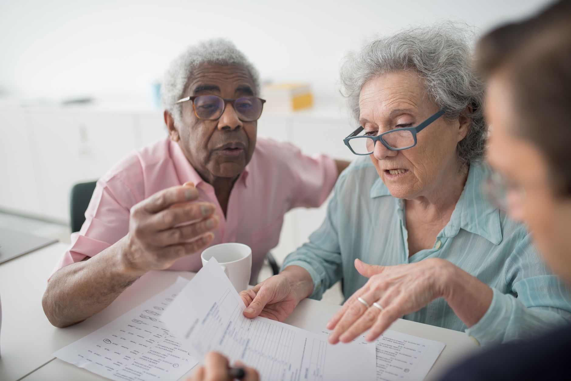 An adult child helping an elderly parent with paperwork