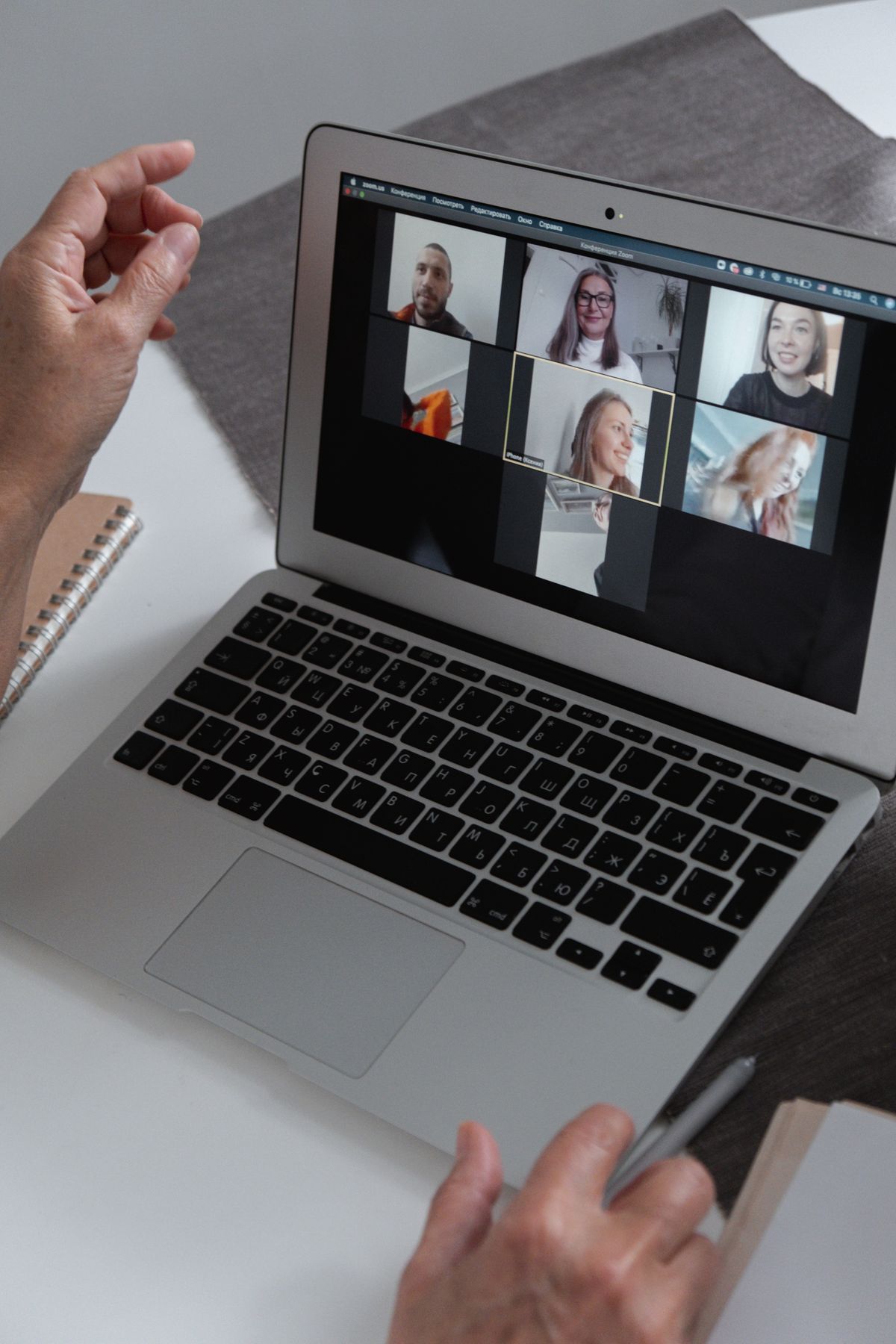 A person on a video call with several participants on a laptop