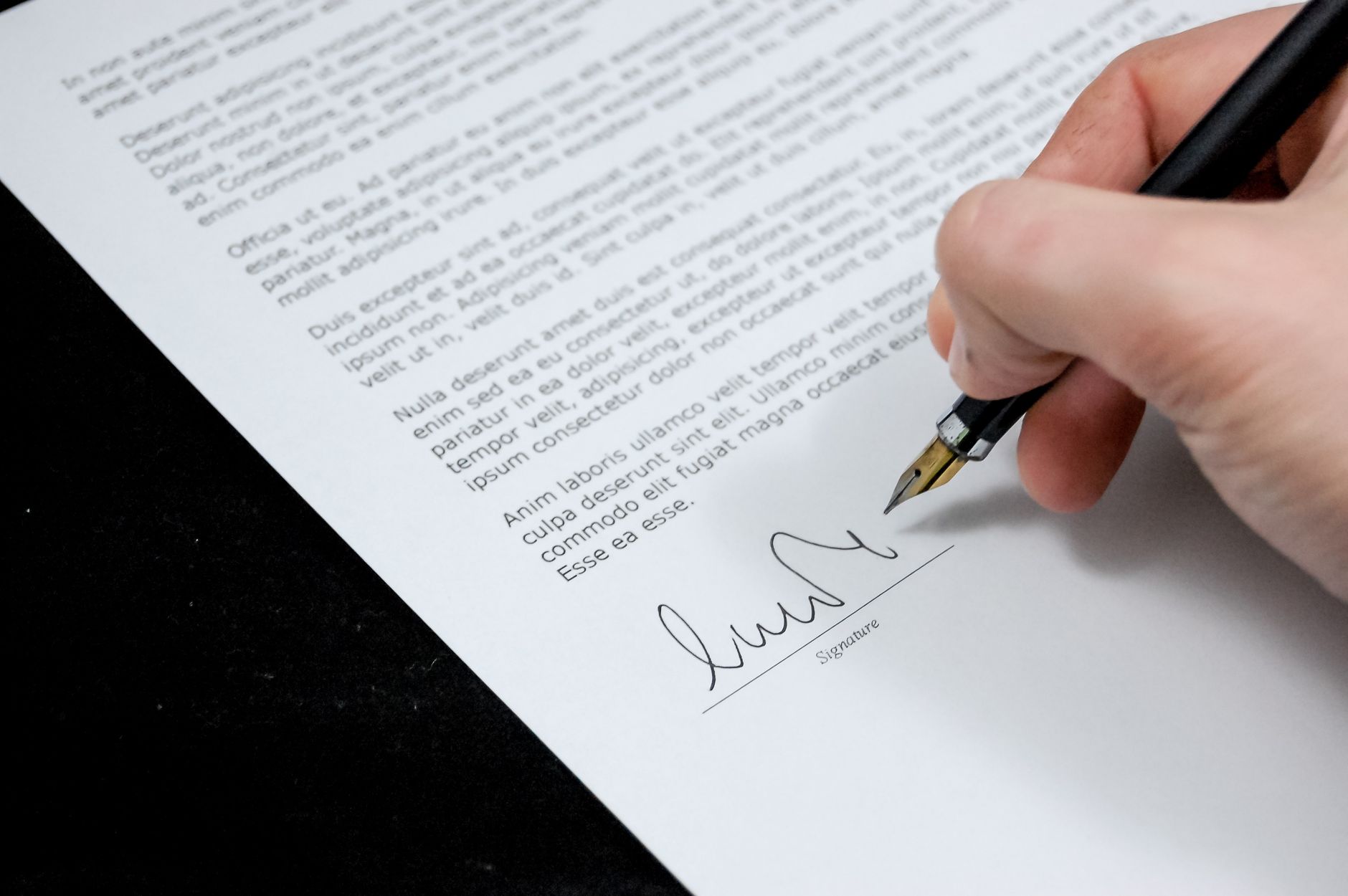 A fountain pen resting on a signed paper document