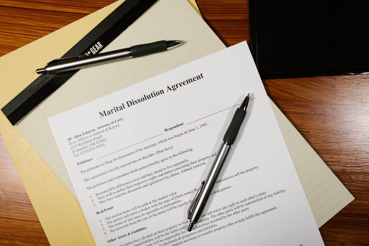 A stack of legal documents with a pen resting on top