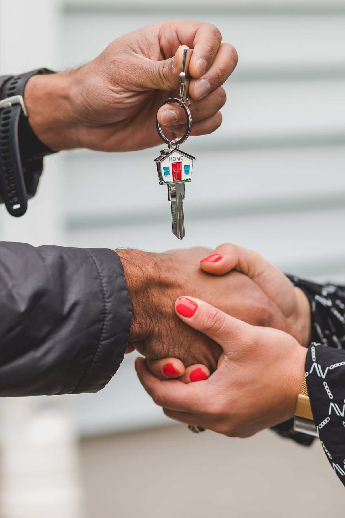 A close-up handshake exchanging a house key